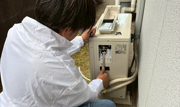 室外機を修理しているスタッフ