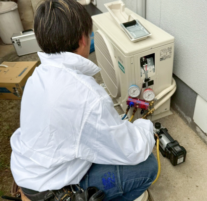 室外機を修理中のスタッフ